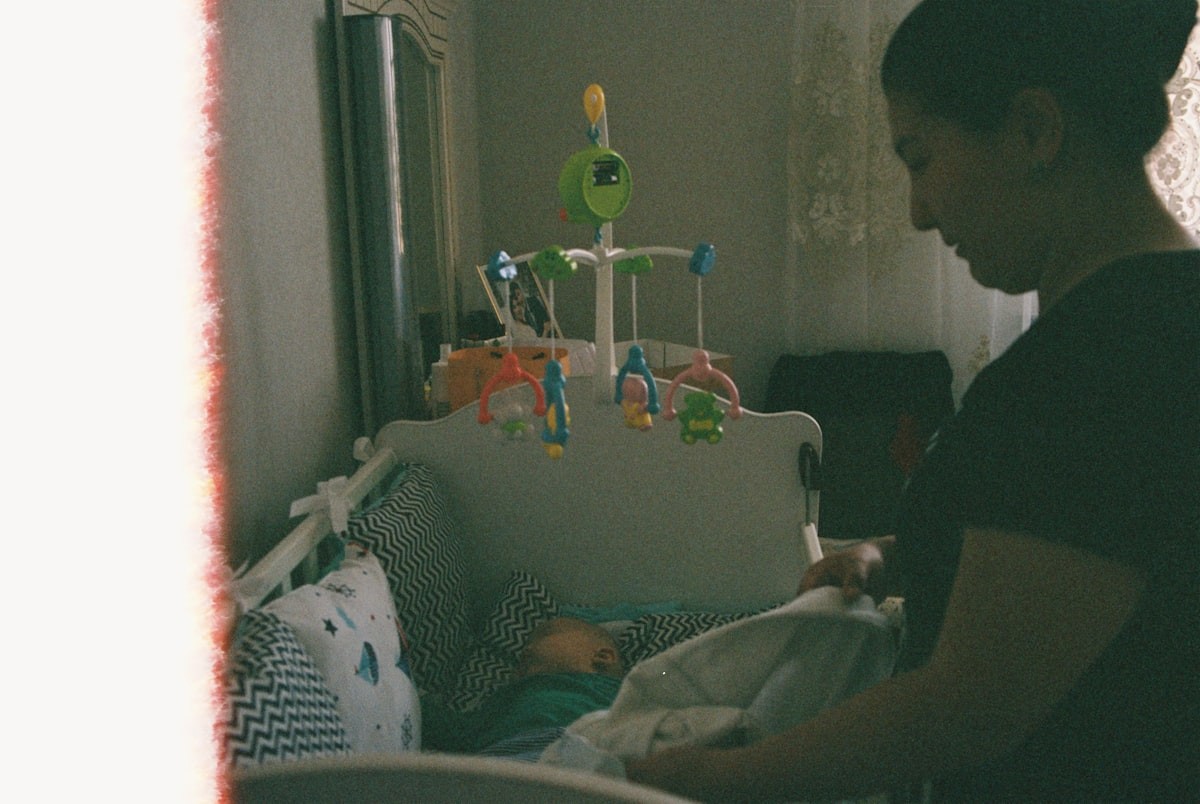 Parent tucking baby into crib during bedtime routine