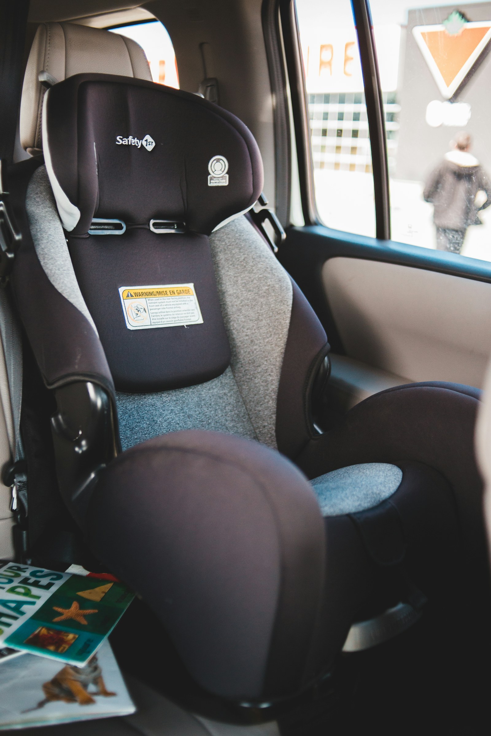 A gray and black convertible car seat installed in a vehicle